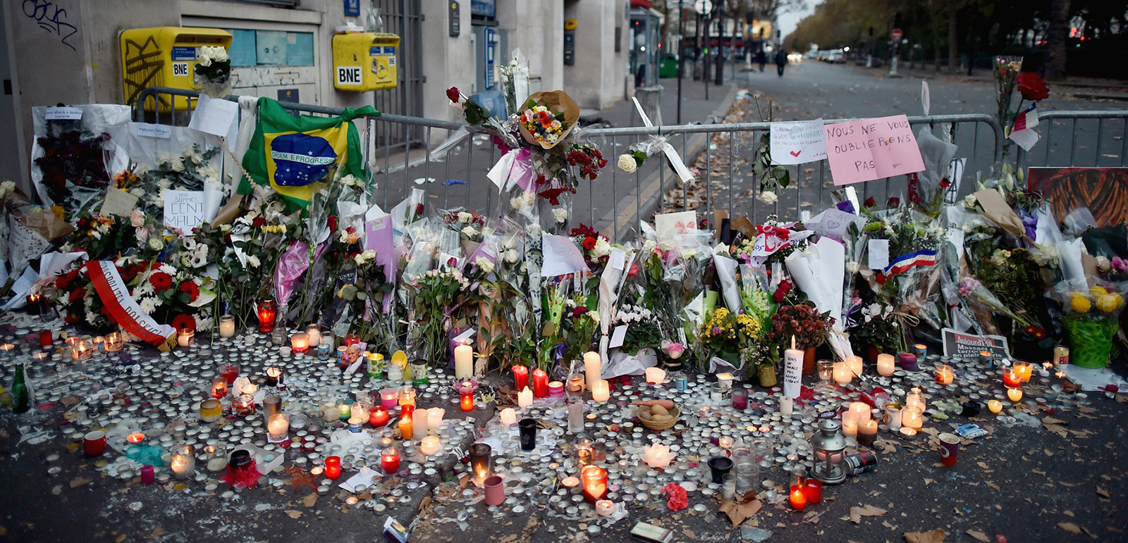 PARIS, FRANCE - NOVEMBER 15: Floweres, candles and tributes cover the pavement near the scene of Friday's Bataclan Theatre terrorist attack on November 15, 2015 in Paris, France. As France observes three days of national mourning members of the public continue to pay tribute to the victims of Friday's deadly attacks. A special service for the families of the victims and survivors is to be held at Notre Dame Cathedral later on Sunday. (Photo by Jeff J Mitchell/Getty Images)