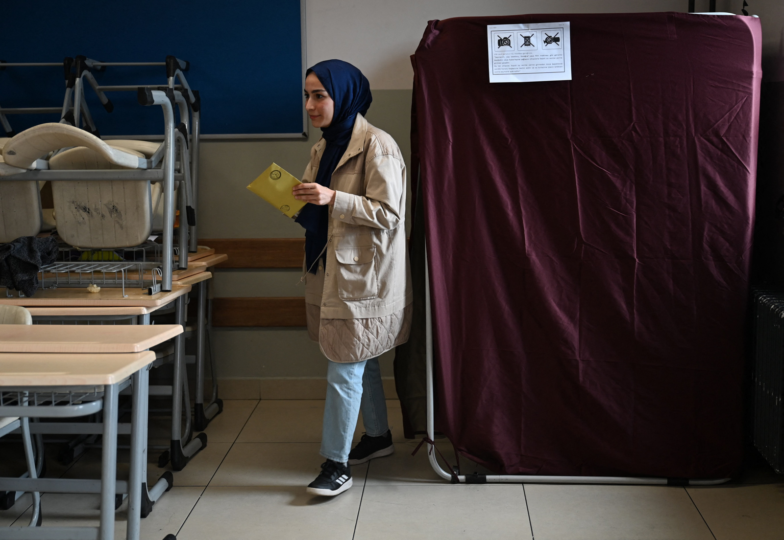 A woman leaves a polling booth at a polling station in Istanbul to vote in the parliamentary and presidental elections in Turkey, on May 14, 2023. Turkey is voting in a momentous election that could extend President Recep Tayyip Erdogan's 21-year grip on power or put the mostly Muslim nation on a more secular course. (Photo by OZAN KOSE / AFP) (Photo by OZAN KOSE/AFP via Getty Images)