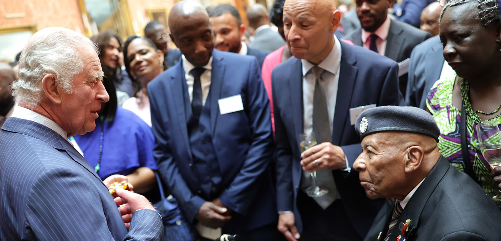 King Charles III speaks with guest at a Buckingham Palace reception to mark the 75th anniversary of the arrival of HMT Empire Windrush, on June 14, 2023