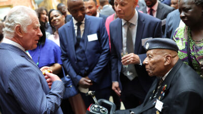 King Charles III speaks with guest at a Buckingham Palace reception to mark the 75th anniversary of the arrival of HMT Empire Windrush, on June 14, 2023