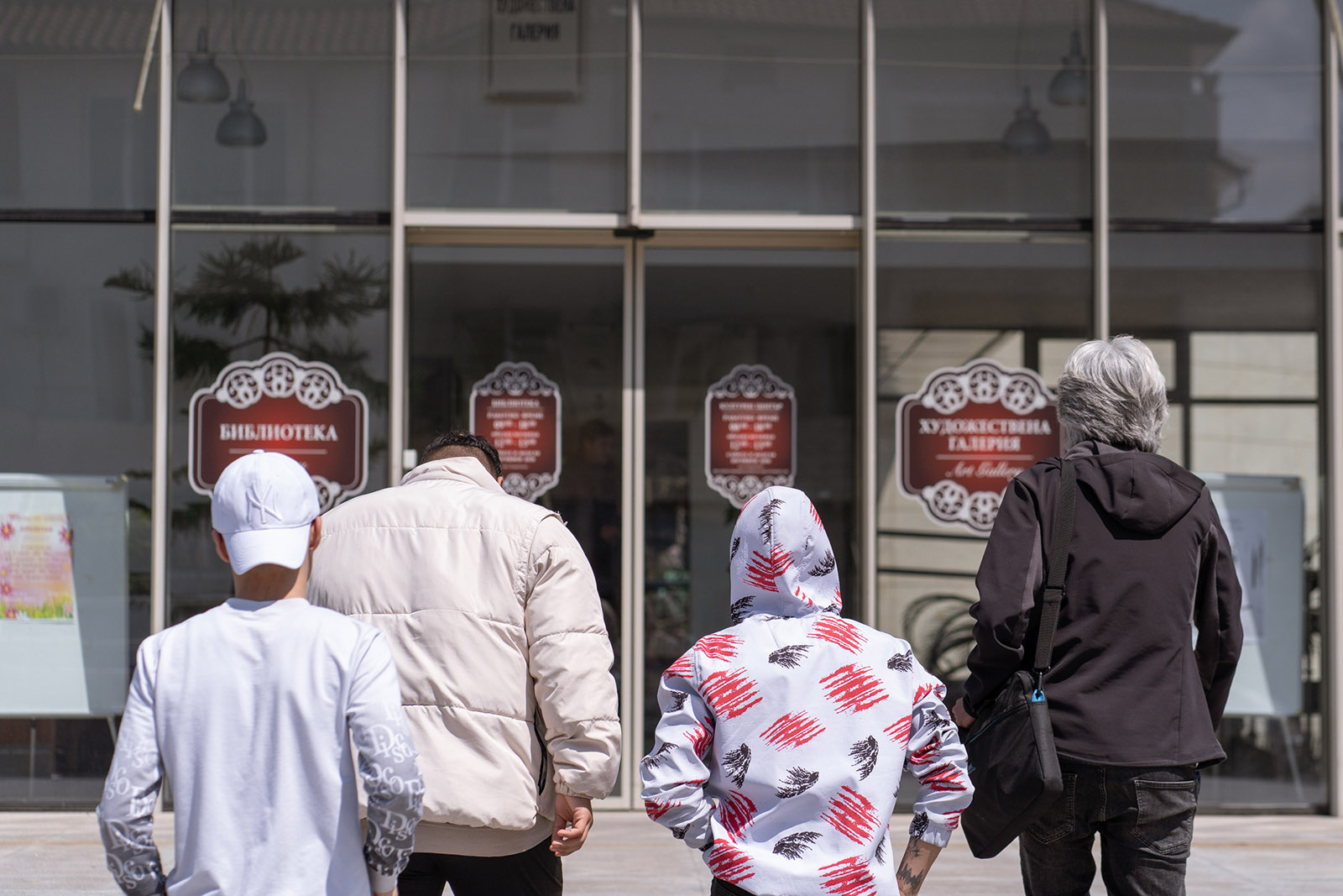 Three unacompanied minors and Hamid Khoshsiar enter the Harmanli Community Center, in Harmanli, Bulgaria, on April 20, 2023. Photography by Nick Palelogos