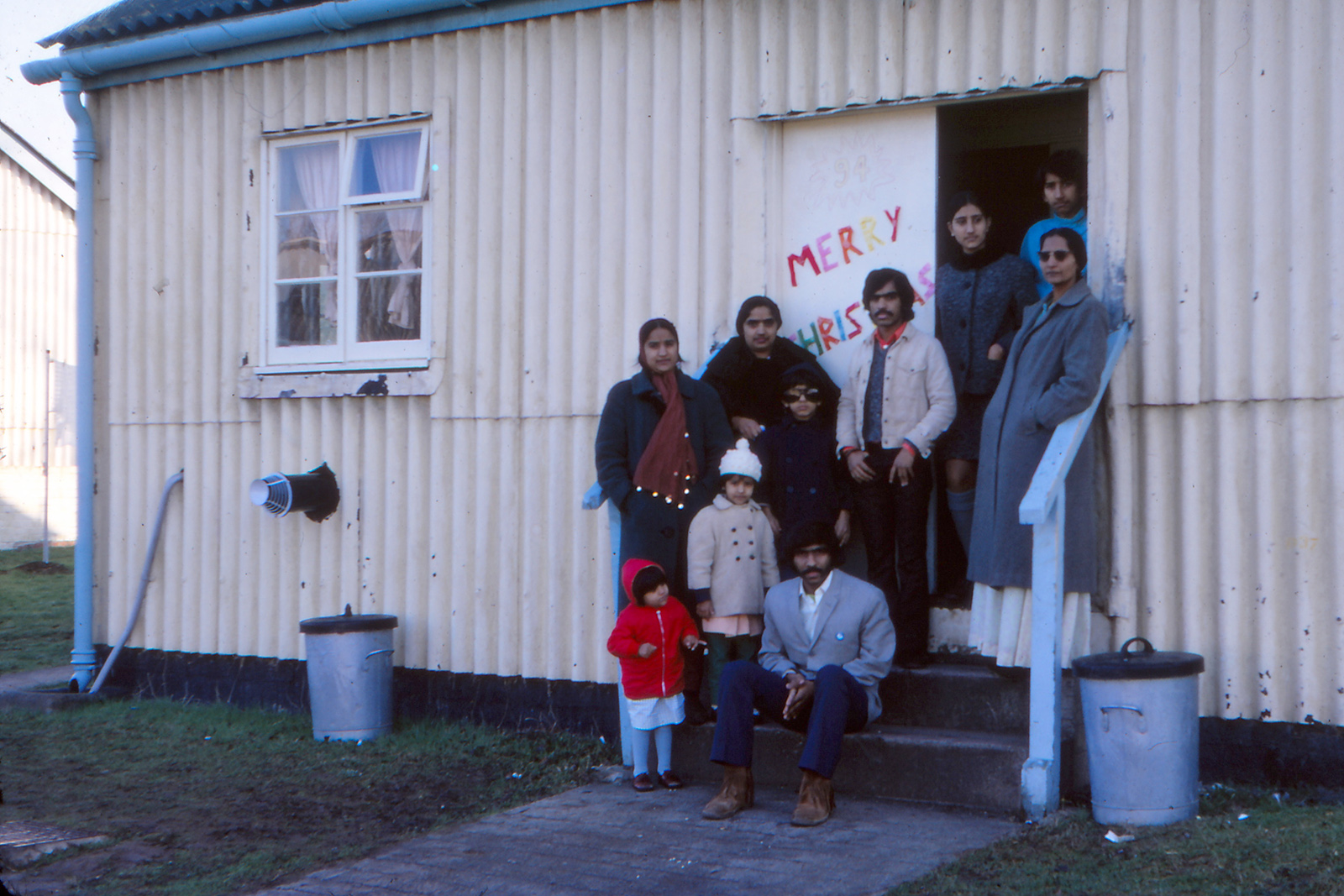 Lucy Fulford, The Exiled. Photo: Christmas 1972 for the Majothis, their extended family and friends, was spent in a corrugated iron billet at Doniford camp, one of the sites housing Ugandan Asian exiles. Photograph courtesy of the Majothi family