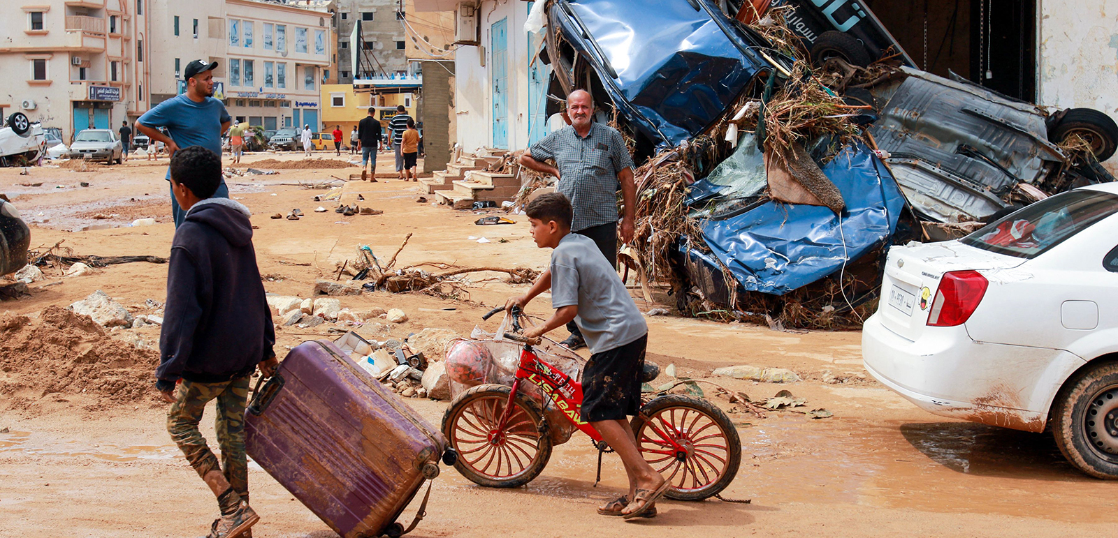 A boy pulls a suitcase past debris in a flash-flood damaged area in Derna, eastern Libya, on September 11, 2023.