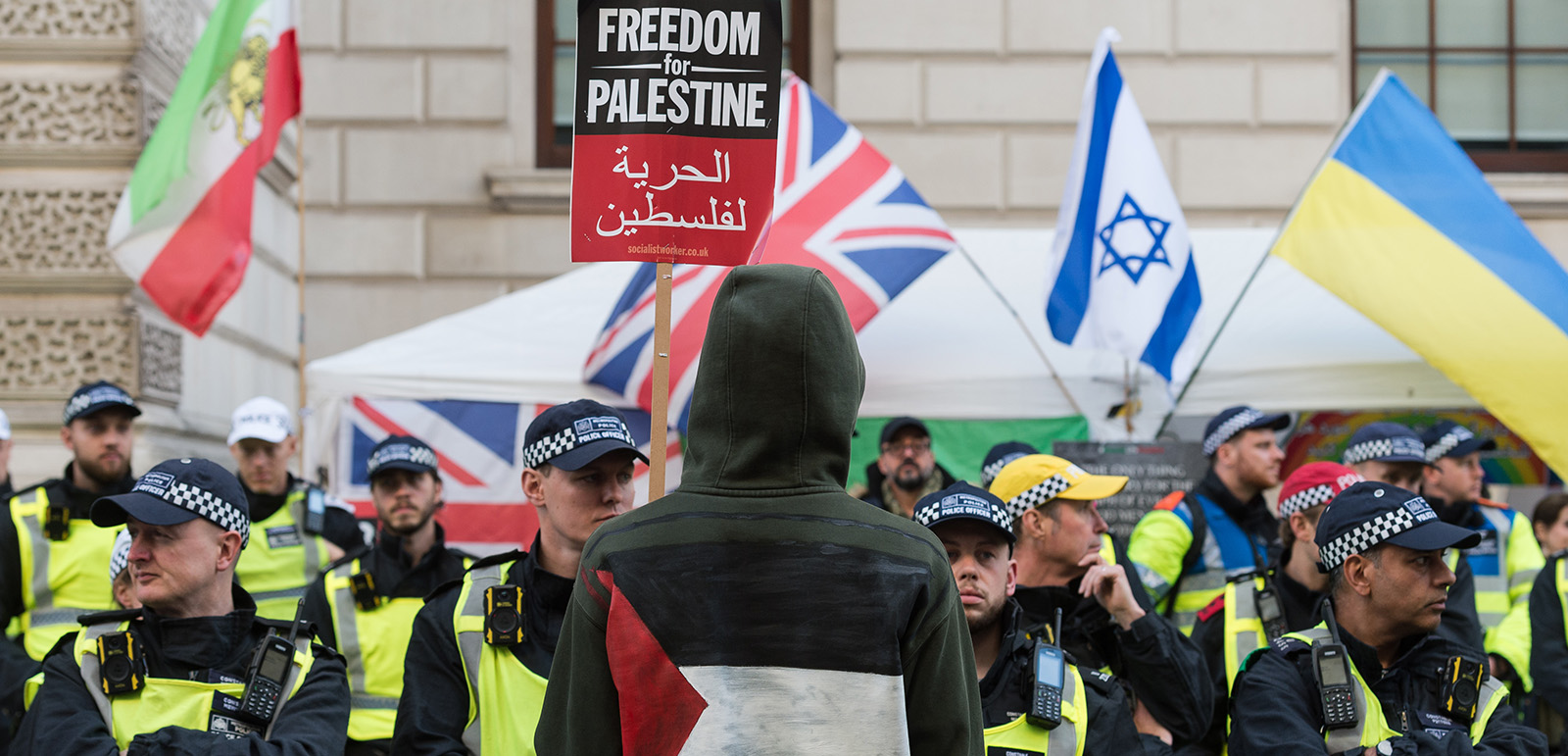Police officers stand guard between a pro-Israel counter demonstration during the Palestine solidarity march in London, organised to demand an end to Israeli airstrikes on the Gaza Strip. Photography by Wiktor Szymanowicz/Future Publishing via Getty Images
