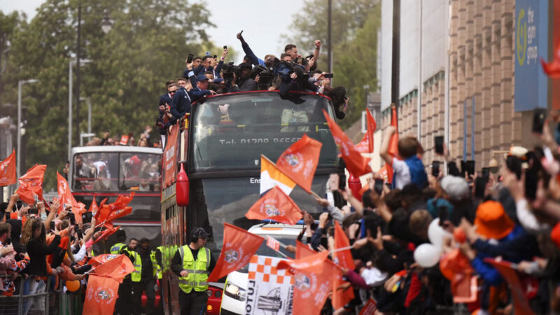 Luton Town football club players and staff parade through the streets of Luton with the Championship playoff trophy in Luton, north of London on May 29, 2023, as they celebrate their promotion to the English Premier League. Luton completed a fairytale journey to the Premier League after winning the Championship playoff final at Wembley on Saturday. Financial experts estimate promotion to world football's most watched league to be worth around £170 million ($210 million) for a club that have been through turmoil since they last played in the top flight 31 years ago. (Photo by Daniel LEAL / AFP)
