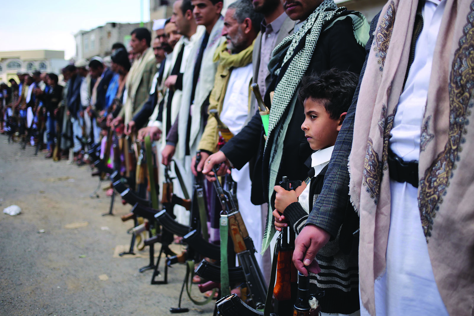 A child joins his father in a tribal gathering in Hasaba, Yemen. Photograph from Unfinished War: A Journey through Civil War in Yemen by Asmaa Waguih