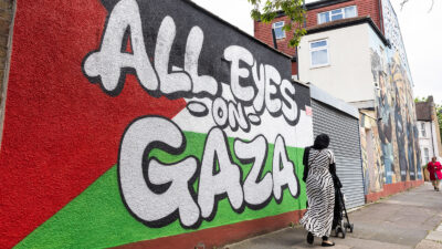 Members of the public pass pro-Palestinian street art in tribute to Palestinian journalists Mohamed Al Masri, Ali Jadallah, Hind Khoudary and Abdulhakim Abu Riash in Ilford on 7th May 2024 in London, United Kingdom. The artwork, which is in two sections, consists of the words 'All Eyes On Gaza' on a Palestinian flag and a painted rendering of a photograph of the four journalists with the words 'Heroes of Palestine' above. It was produced by Creative Debuts, an art platform providing opportunities and support to emerging artists from around the world. (photo by Mark Kerrison/In Pictures via Getty Images)