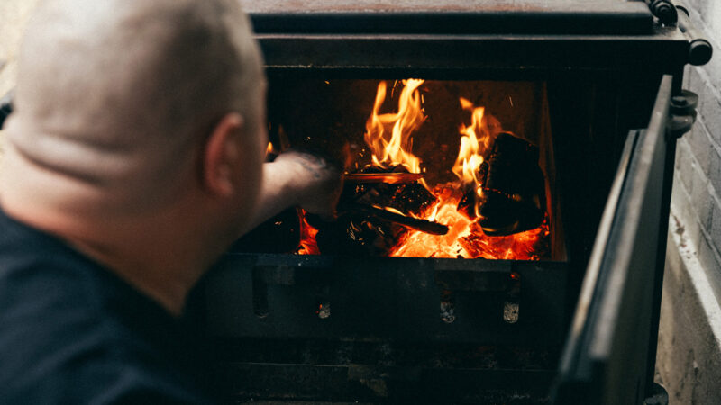 Burnt Smokehouse, Leyton Owner and chef Tiberius Tudor working on the fire. Photo courtesy of Burnt Smokehouse