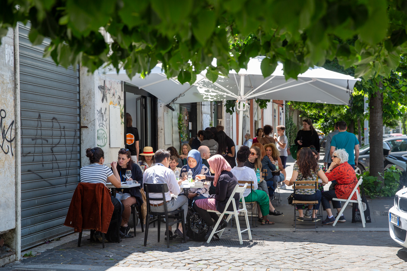 Cafe-hoppers sit outside a kiosk in Rome. Photography for Hyphen by Francesca Leonardi