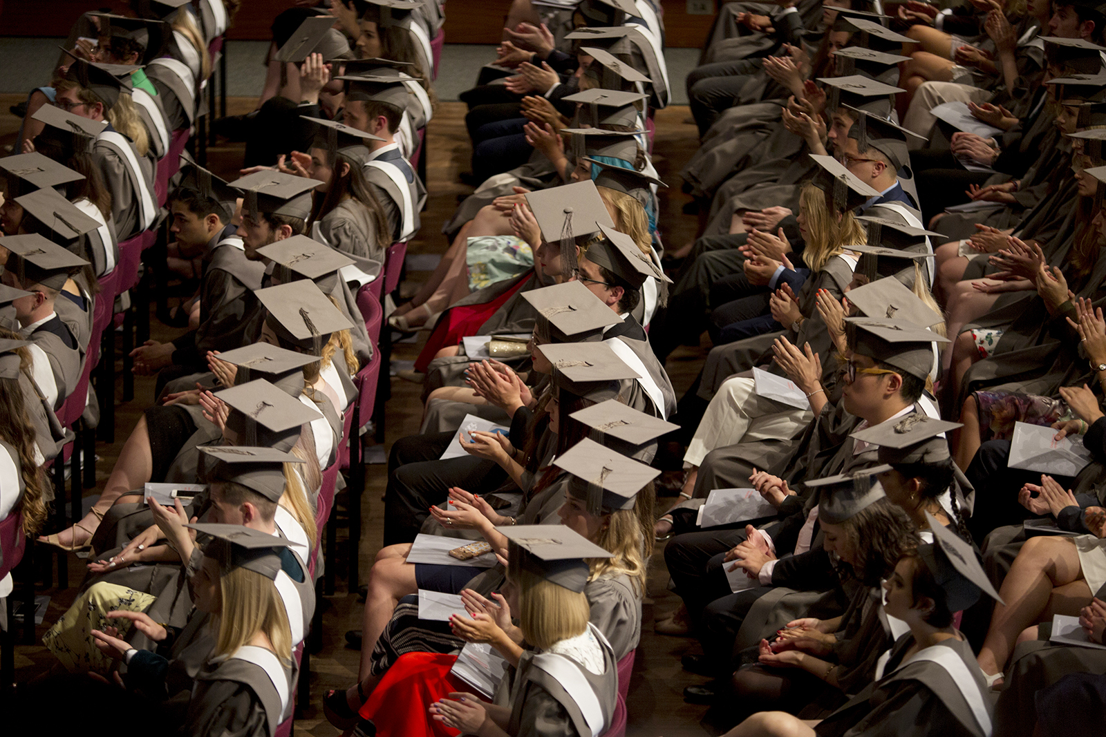 Young graduates wearing rented gowns and mortarboards applaud a speech in the central hall of their university during their graduation ceremony, on 13 July 2017, at the University of York, England. Photo by Richard Baker / In Pictures via Getty Images