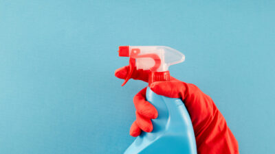 Hand holding cleaning spray. Photo by workink/Getty Images