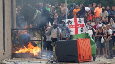 Demonstrators toss a trash bin during an anti-immigration protest, in Rotherham, Britain, August 4, 2024. REUTERS/Hollie Adams