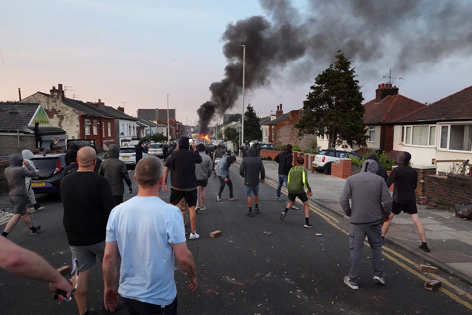 SOUTHPORT, ENGLAND - JULY 30:  Protesters throw stones at police after disorder broke out on July 30, 2024 in Southport, England. Rumours about the identity of the 17-year-old suspect in yesterday's deadly stabbing attack here have sparked a violent protest. According to authorities and media reports, the suspect was born in Cardiff to Rwandan parents, but the person cannot be named due to his age. A false report had circulated online that the suspect was a recent immigrant who crossed the English Channel last week and was "on an MI6 watchlist." (Photo by Getty Images/Getty Images)