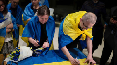 Nariman Dzhelyal, right, deputy head of the Mejlis of the Crimean Tatar People, signs the Ukrainian national flag in Kyiv airport, Ukraine, Saturday, June 29, 2024. Ten Ukrainians who had been held prisoners for years, were released from Russian captivity on Friday with a mediation of Vatican, said Ukraine's President Volodymyr Zelenskyy. Photo by Alex Babenko