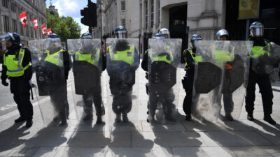 A line of riot police block the entrance to Whitehall at a Black Lives Matter protest action in central London on June 13, 2020, in the aftermath of the death of unarmed black man George Floyd in police custody in the US. - Police in London have urged people planning to attend anti-racism and counter protests on Saturday not to turn out, citing government regulations banning gatherings during the coronavirus pandemic. Photo by Daniel Leal / AFP