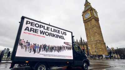 The Conservatives’ iconic ‘Labour Isn’t Working’ advert has been subverted by non-profit People Like Us as part of a new campaign designed to raise the alarm on pay inequality faced by ethnic minority workers in the UK. The reimagined artwork depicts a line of people from Black, Asian, Mixed Race and minority ethnic backgrounds “queuing for a pay rise”, with text highlighting how they’re paid an average of 16% less than their white counterparts. Photo by Mikael Buck