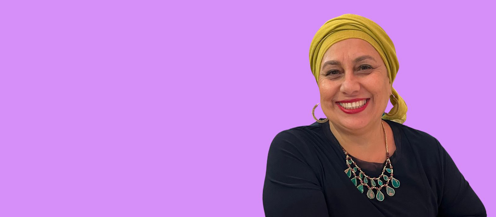 Rizwana Hamid wearing a yellow head scarf and smiling