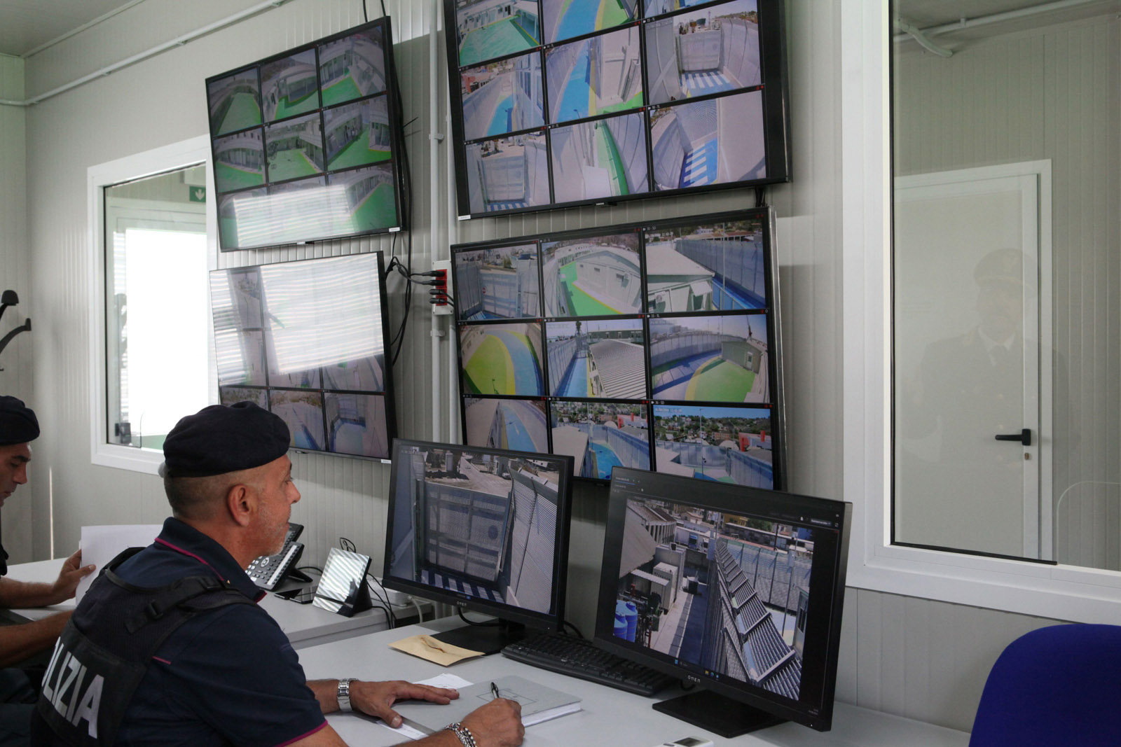 An Italian police officer observes surveillance cameras in an Italian refugee arrival camp in Shengjin, northern Albania. 