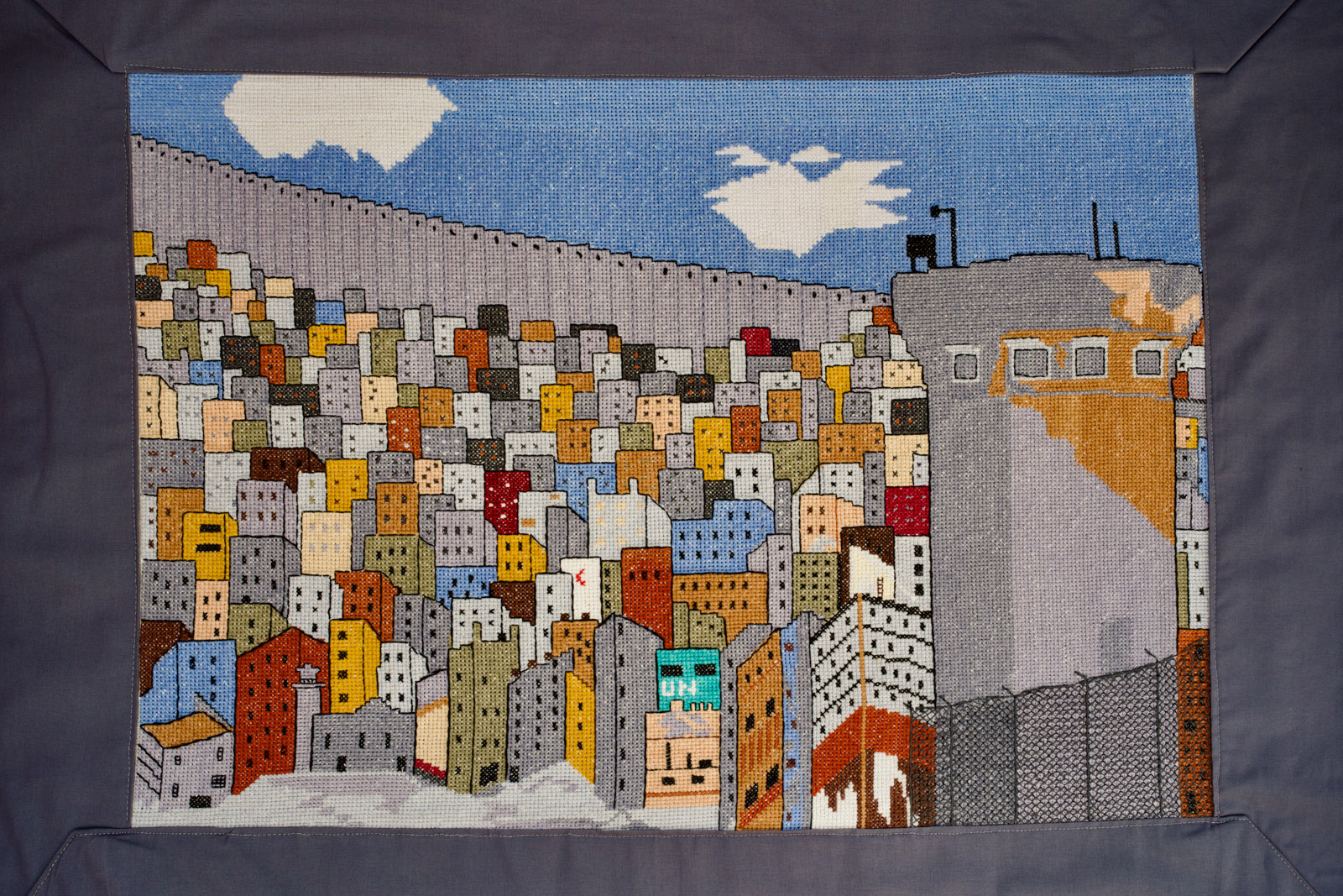 Embroidery of a city enclosed by a wall, which features in the Art of Palestine exhibition at London's P21 Gallery