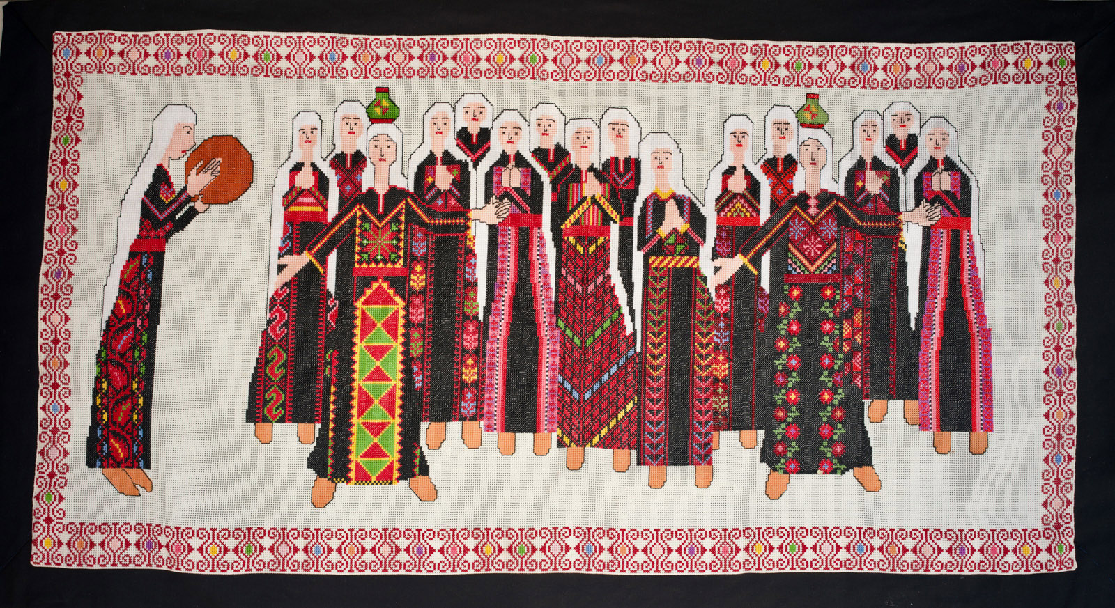 A piece of tatreez embroidery showing a group of women, which features in the Art of Palestine exhibition at London's P21 Gallery