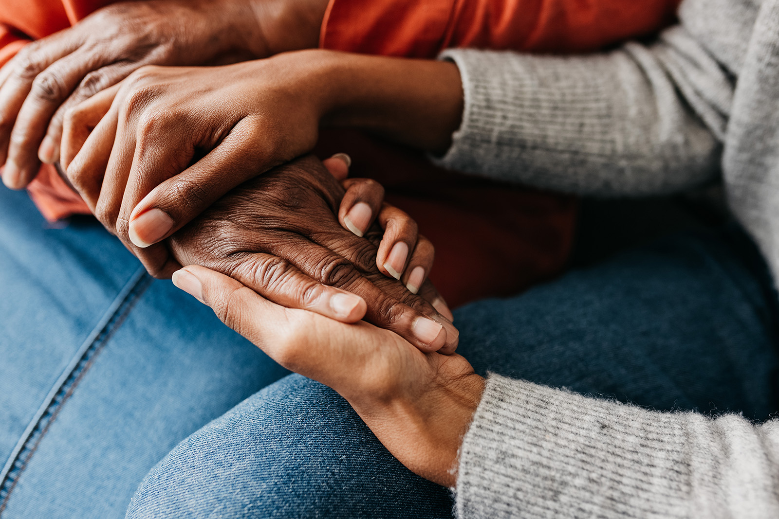 A young daughter holding hands of mother tightly in comfort and reassurance.