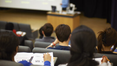 Back of students reading in university lecture