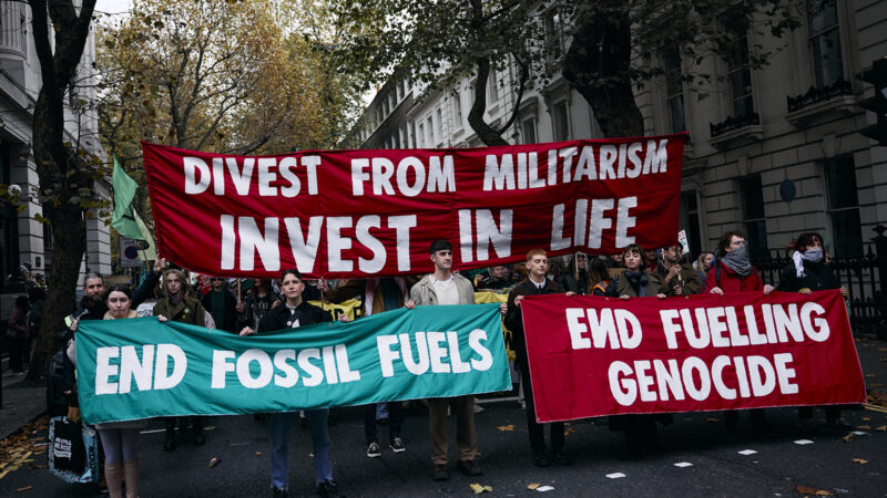 Protesters hold up placards as they gather for a combined March for Global Climate Justice, organised by the Cimate Justice Coalition, in London on 16 November 2024.