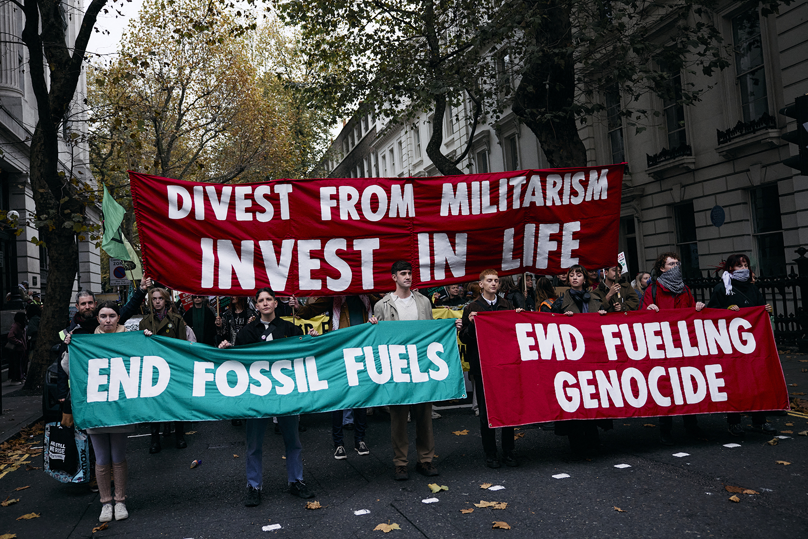 Protesters hold up placards as they gather for a combined March for Global Climate Justice, organised by the Cimate Justice Coalition, in London on 16 November 2024.