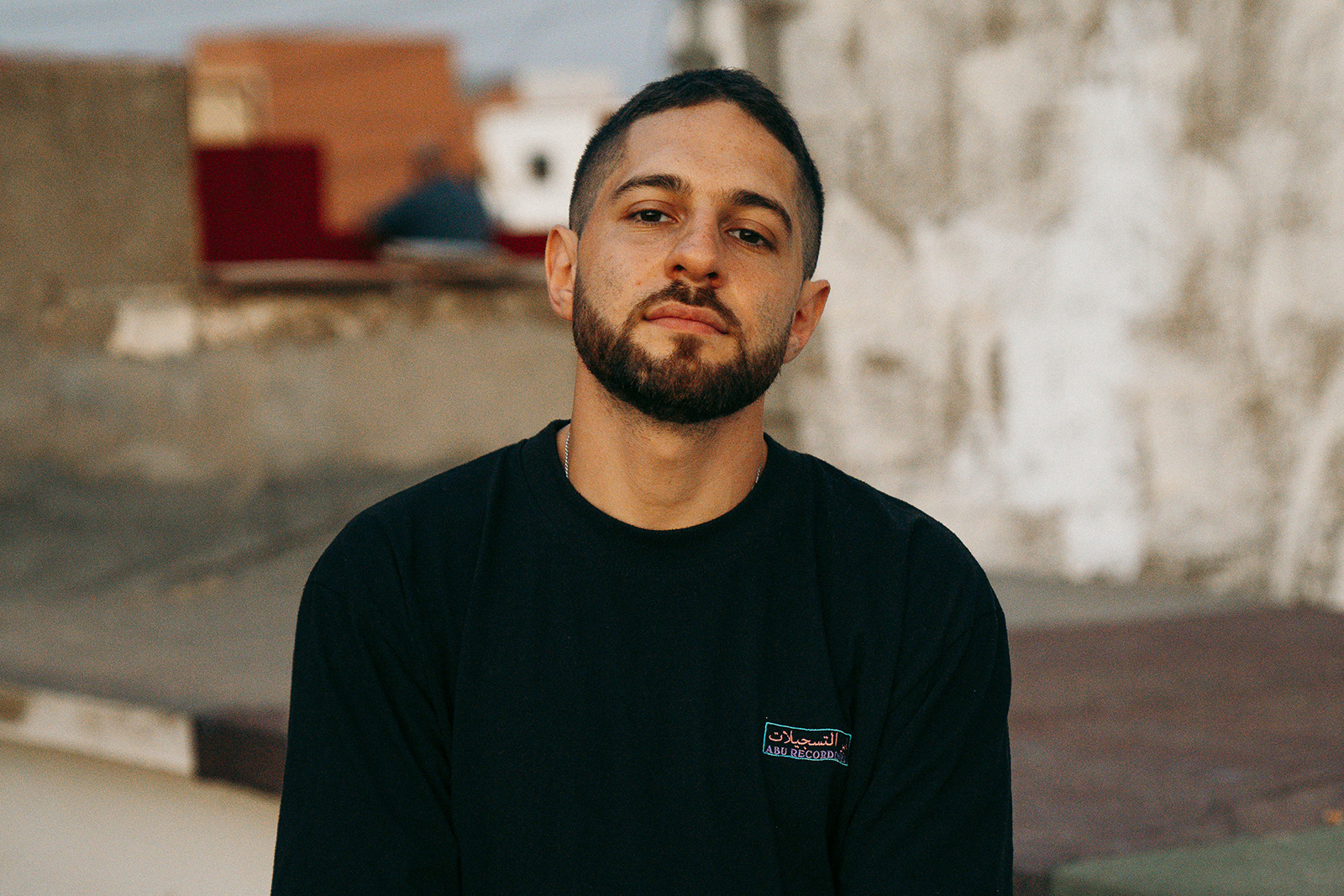 Electronic producer Waleed facing the camera wearing a black top