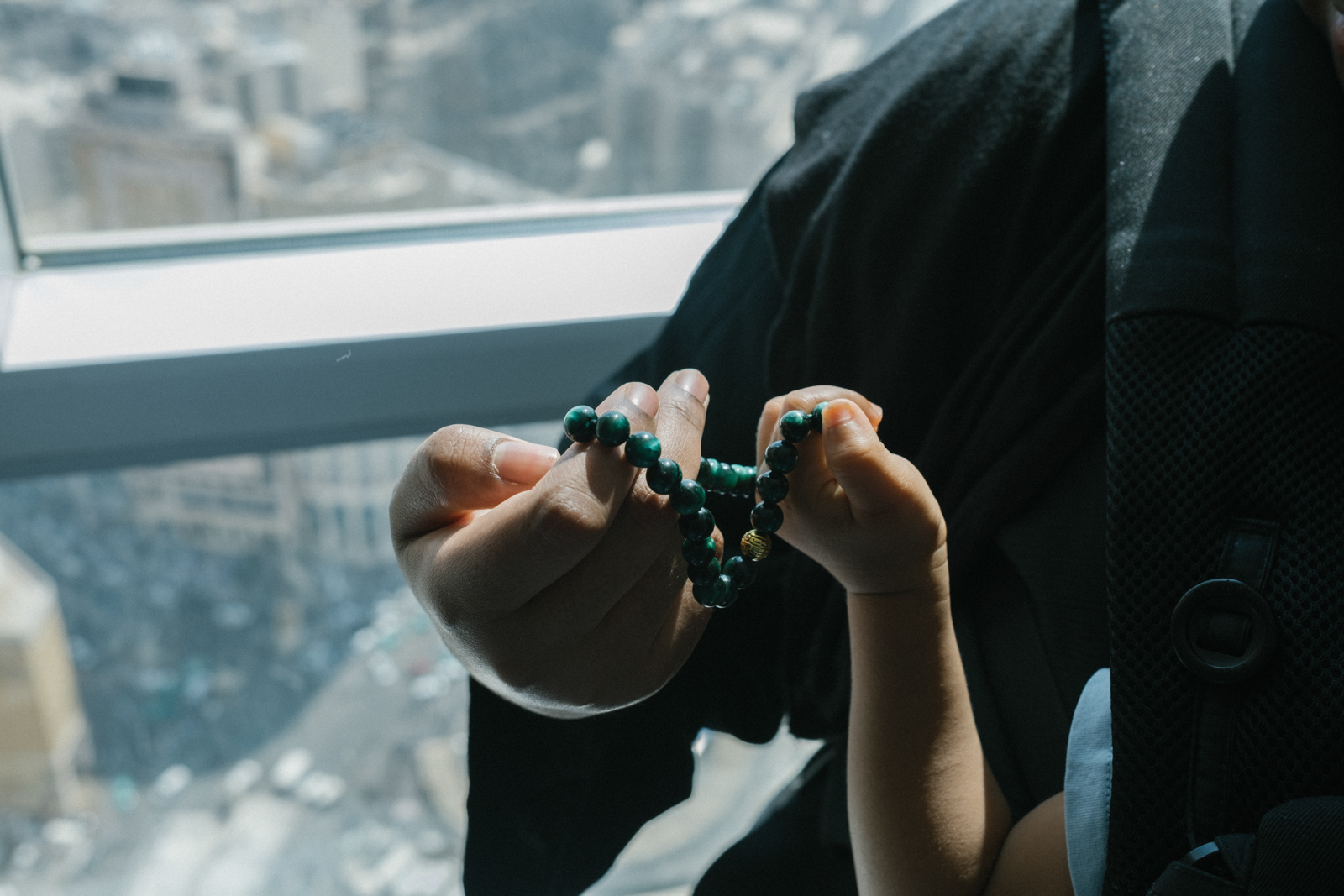 Amaal Said holding prayer beads with her son in Mecca.