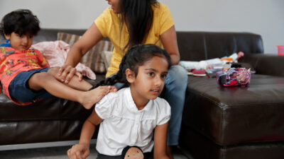 Lively 3 year old boy being told off by mature mum as she tries to get the children ready for school in the morning, distraction, distracted, multitasking