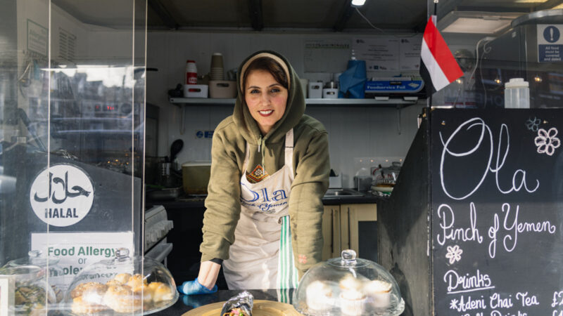 Portrait shot of Abeer Yahya Mohammed, proprietor of Ola Pinch of Yemen, leaning on her kitchen worktop