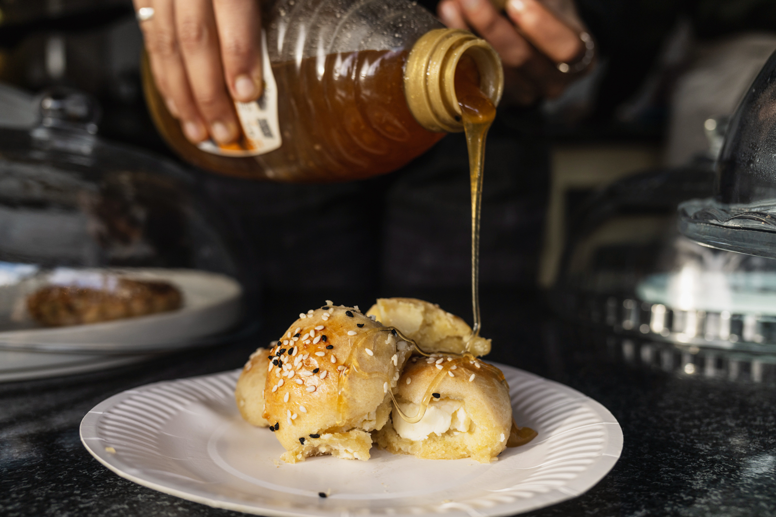 Honey being drizzled on khaliat nahal at Ola Pinch of Yemen, Cricklewood Market Place