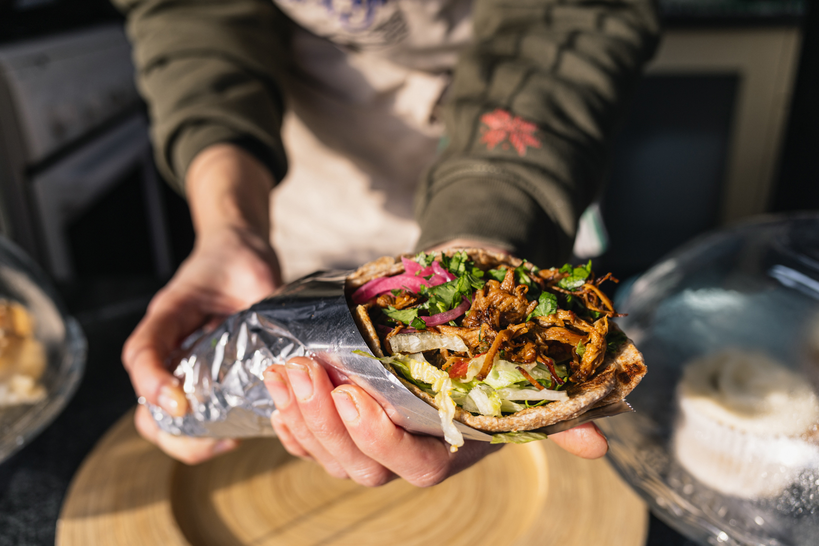 Abeer Yahya Mohammed holding freshly made shredded beef wrap at Ola Pinch of Yemen, Cricklewood Market place