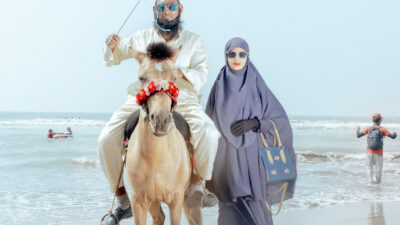 Man on a horse and woman standing next to him on the beach at Cox's Bazar