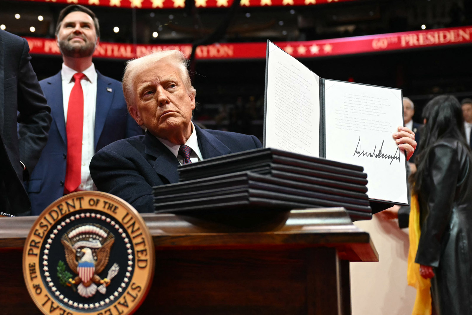 US president Donald Trump holds an executive order he just signed during the inaugural parade inside Capital One Arena, in Washington DC, on 20 January 2025. 