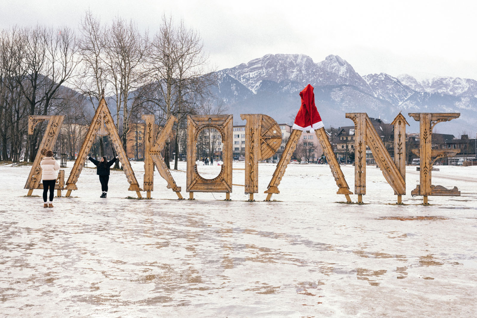 Tourists take pictures at a vantage point with a wooden Zakopane sign on the Górna Równia Krupowa in Zakopane, Poland, January 9, 2025. 