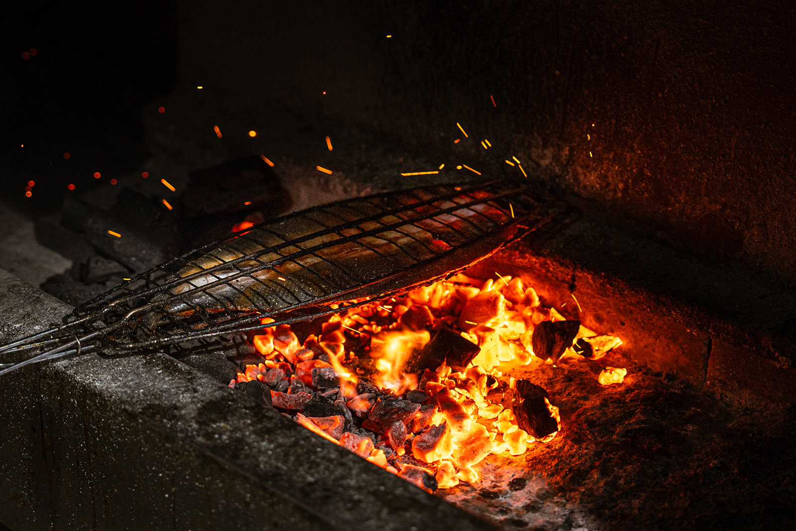 Griling sea bass in the kitchen at Bekhal Restaurant in Greenford, London, United Kingdom