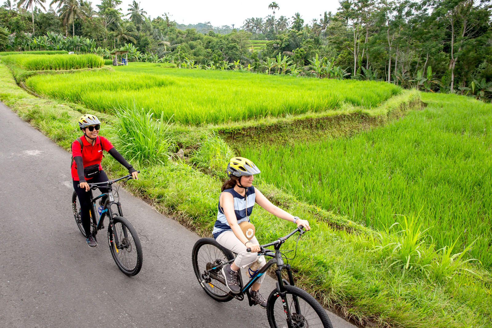 Queenie Shaikh (right), cycling with tour leader Srix in the rice fields of Bayung Gede.