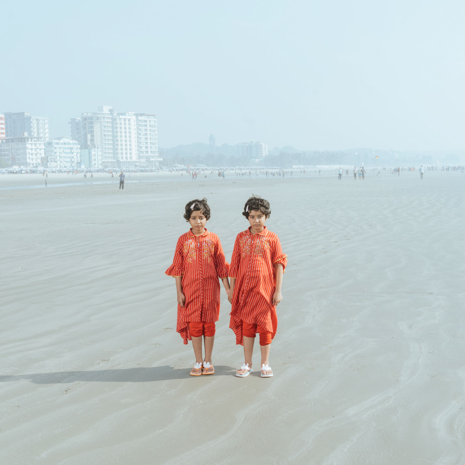 Twin sisters poses for a portrait at the Cox’s Bazar beach, they came to visit Cox’s Bazar as a tourist with their parents. 