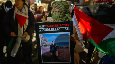 A protestor holds a placard during the demonstration. Hundreds of Palestine Action protestors congregated at HMP Brixton Prison to lobby for the release of all Political Prisoners on their annual New Year's Eve "Noise Demo".
