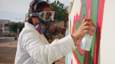 Sudanese artist Assil Diab spray painting in Khartoum. Photograph courtesy of Foxtrot Films