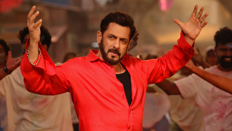 Salman Khan in a red shirt with arms raised in a scene from Sikander