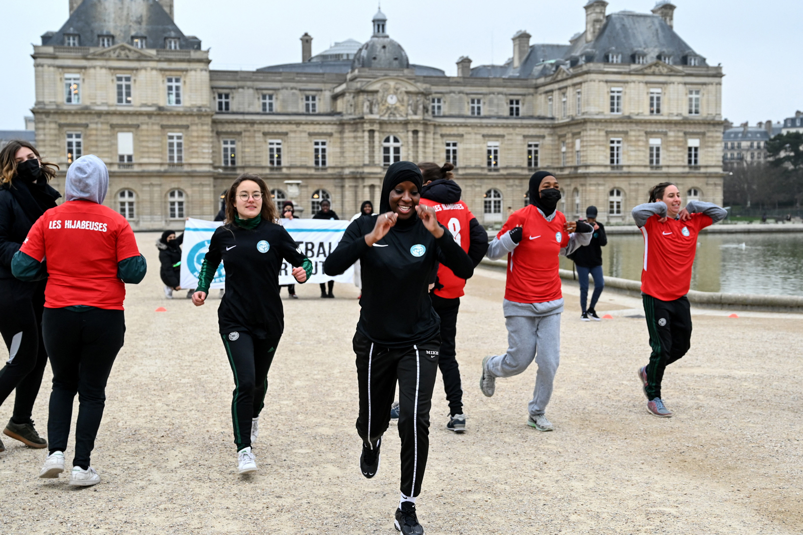 Women calling themselves the Hidjabers warm up before playing football in the Luxembourg garden facing the French Senate in Paris on January 26, 2022, as a protest after senators voted in favour of a ban of the wearing of religious symbols during events and competitions organised by sports federations.