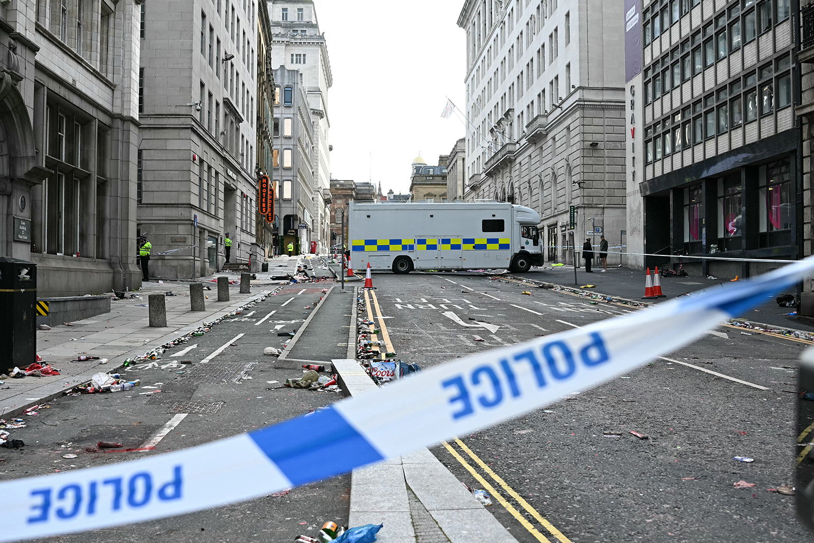 Police officers stand at a cordon on in Water Street in Liverpool, north-west England on May 27, 2025, after a car ploughed in to crowds gathered to watch an open-top bus victory parade for Liverpool's Premier League trophy parade. Police said Monday they were not treating a Liverpool car ramming which left 27 people hospitalised as terrorism, after a vehicle ploughed into crowds celebrating Liverpool's Premier League football title. "We believe this to be an isolated incident, and we are not currently looking for anyone else in relation to it," Merseyside Police Assistant Chief Constable Jenny Sims told a press conference, adding a 53-year-old British man had been arrested. (Photo by Paul ELLIS / AFP) (Photo by PAUL ELLIS/AFP via Getty Images)