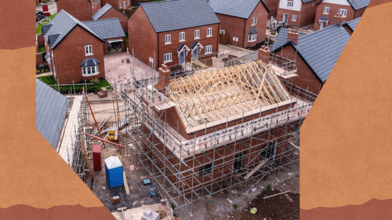 An aerial view of new build homes on a new housing estate with the roof exposed and wooden rafters and beams showing