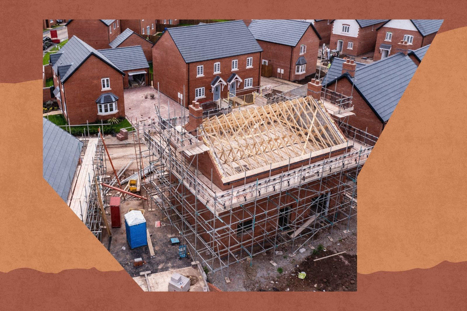 An aerial view of new build homes on a new housing estate with the roof exposed and wooden rafters and beams showing