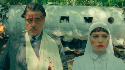 Benicio Del Toro as Zsa-Zsa Korda and Mia Threapleton as Liesl in Wes Anderson's The Phoenician Scheme.