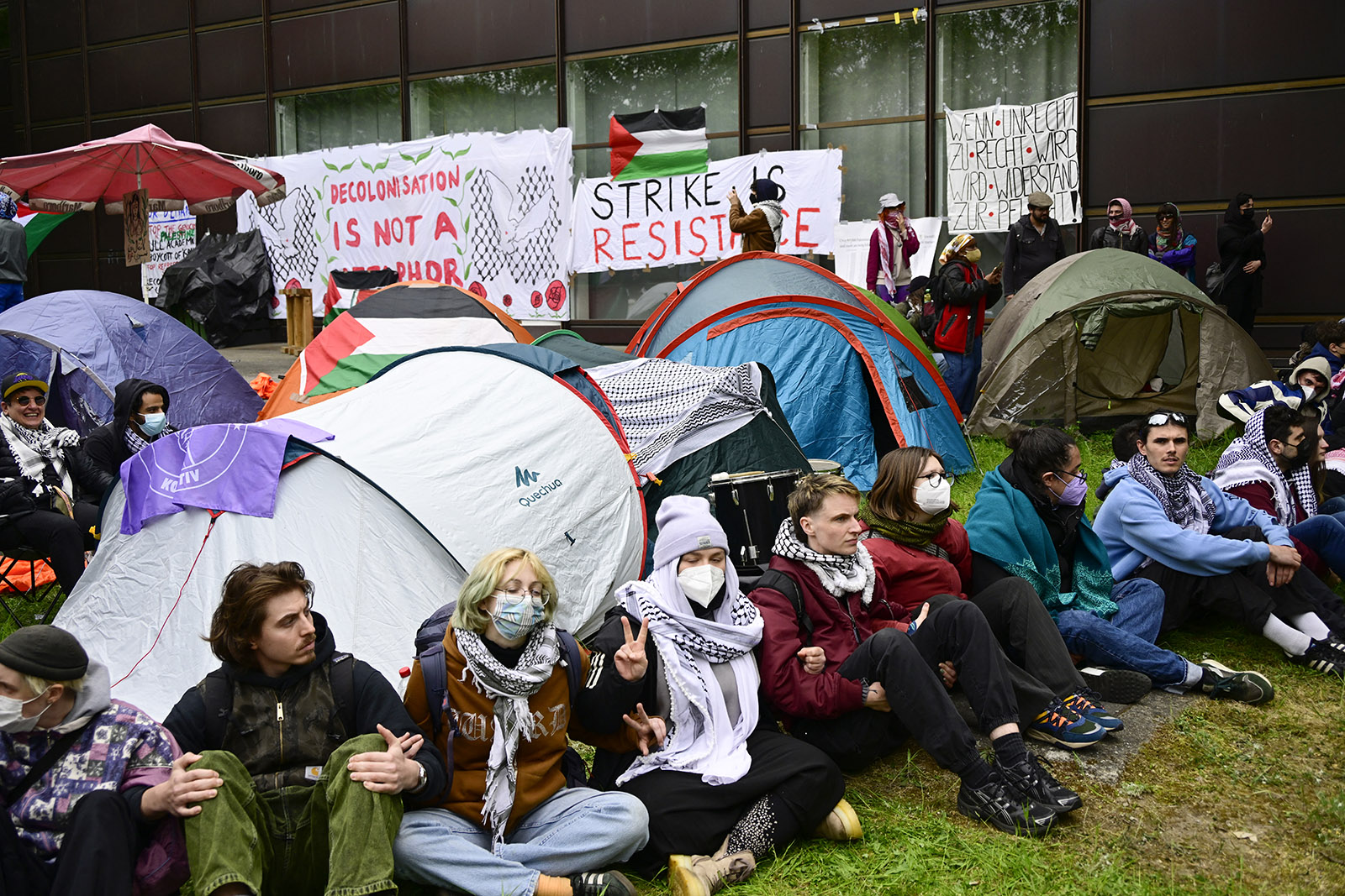 Pro-Palestinian activists sit in front of tents set up at the university campus of the Free University of Berlin, Germany, on May 7, 2024 as they demonstrate against Israel's war in the Gaza Strip which was sparked by Hamas's unprecedented October 7 attack. According to local media reports, activists set up a protest camp with tents in a courtyard of the university. The university has ordered the evacuation and called the police, who have cordoned off the area.