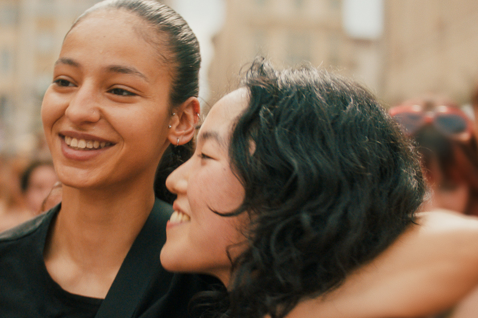 Two young women embrace, smiling